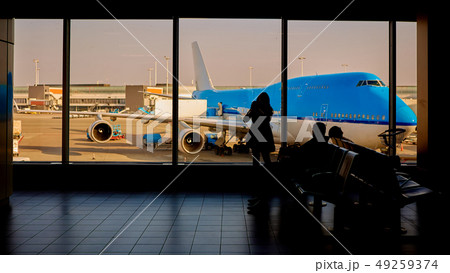 people in airport waiting for departure, silhouette of woman passenger traveling with luggage people in airport waiting for departure, silhouette of woman passenger traveling with luggage 49259374