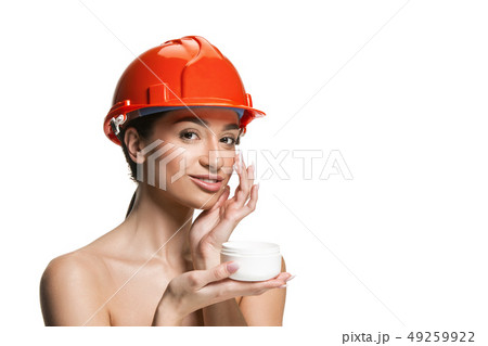Portrait of confident female worker in orange helmet Portrait of confident female worker in orange helmet 49259922