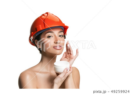 Portrait of confident female worker in orange helmet Portrait of confident female worker in orange helmet 49259924