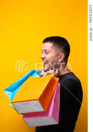 Image of happy brunet man with shopping bags on orange background Image of happy brunet man with shopping bags on orange background 49261825