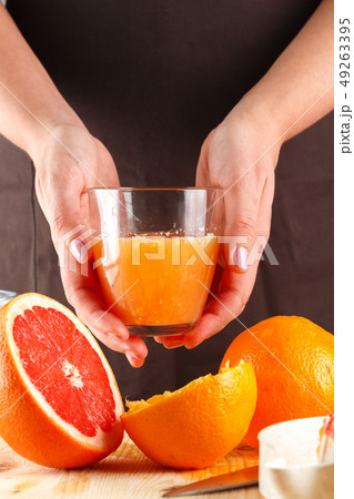 girl holding a glass of fresh citrus juice girl holding a glass of fresh citrus juice 49263395