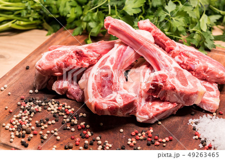 raw lamb chops on a wooden board for barbecue 49263465