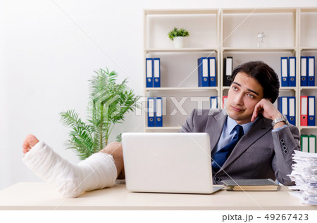 Leg injured employee working in the office Leg injured employee working in the office 49267423