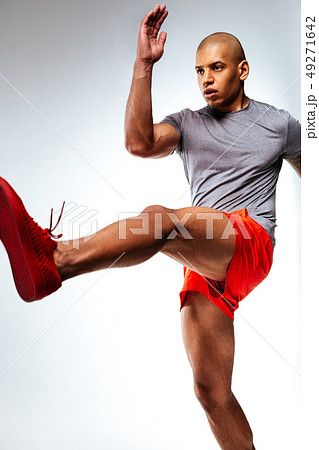 Man moving his arm and leg upwards Man moving his arm and leg upwards 49271642