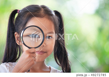 asian girl looking through a magnifying glass 49272785