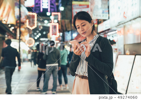 woman texting sms cellphone in city at night 49274060