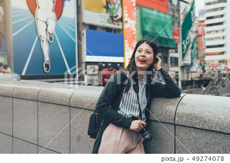 woman with camera standing leaning on bridge woman with camera standing leaning on bridge 49274078