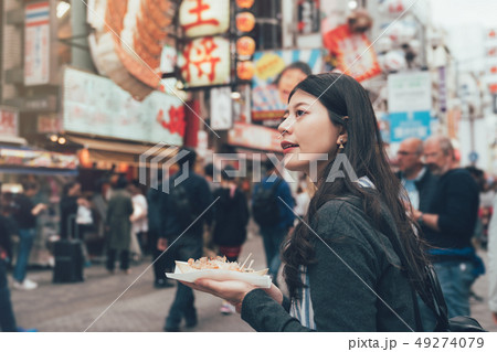 woman sightseeing in teeming shopping area woman sightseeing in teeming shopping area 49274079
