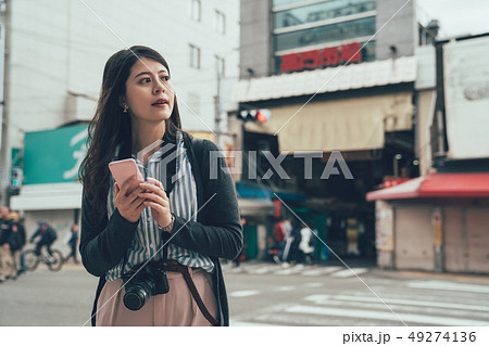 girl using cell phone searching online map app girl using cell phone searching online map app 49274136