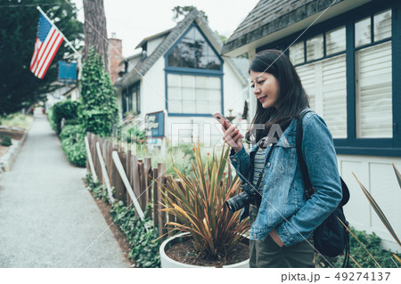 woman standing on street road by garden plants woman standing on street road by garden plants 49274137