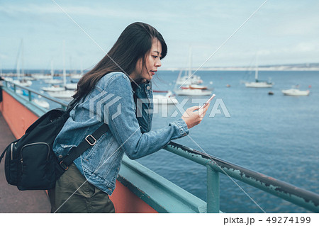 young local asian lady holding cellphone waiting young local asian lady holding cellphone waiting 49274199