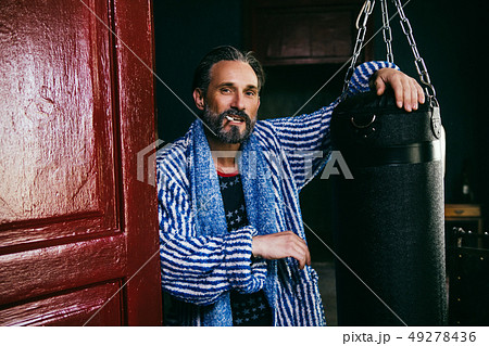 A Brutal Looking Man With a Beard Smokes a Cigarette After Taking a Shower. A Brutal Looking Man With a Beard Smokes a Cigarette After Taking a Shower. 49278436