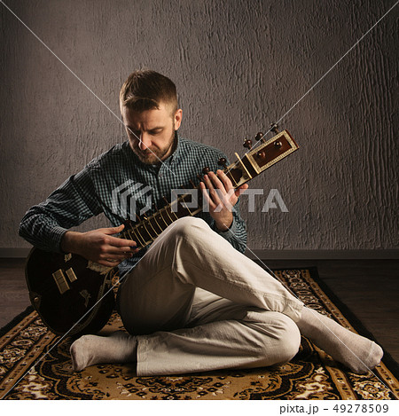 Portrait of a European man playing the sitar 49278509