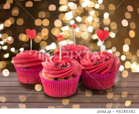 close up of cupcakes with heart cocktail sticks close up of cupcakes with heart cocktail sticks 49280382