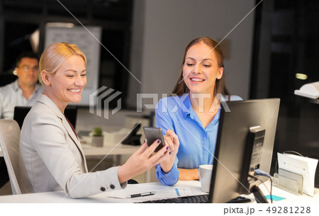 businesswomen with smartphone late at night office 49281228