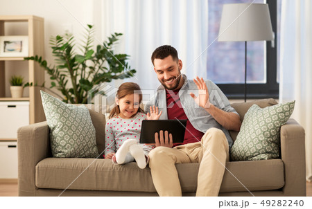 father and daughter having video call on tablet pc 49282240