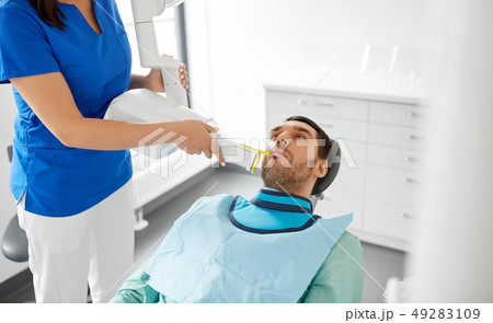 dentist making dental x-ray of patient teeth dentist making dental x-ray of patient teeth 49283109