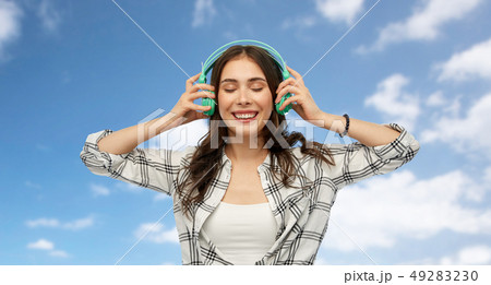 happy young woman or teenage girl with headphones happy young woman or teenage girl with headphones 49283230