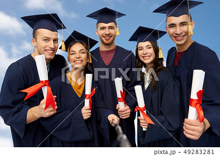 happy graduates with diplomas taking selfie 49283281