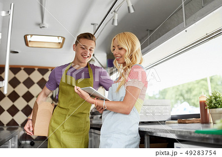 couple of sellers with tablet pc at food truck 49283754