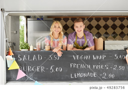 couple of happy young sellers at food truck couple of happy young sellers at food truck 49283756