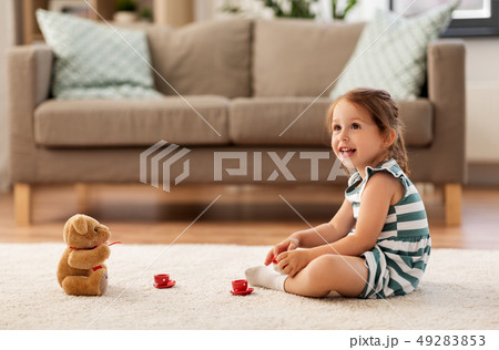 little girl playing with toy tea set at home 49283853