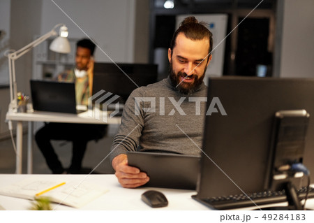 creative man with computer working late at office 49284183