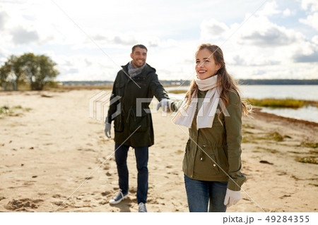 couple walking along autumn beach couple walking along autumn beach 49284355