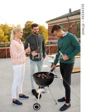happy friends having bbq party on rooftop happy friends having bbq party on rooftop 49284356