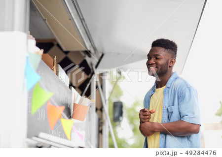 male customer looking at billboard at food truck 49284476