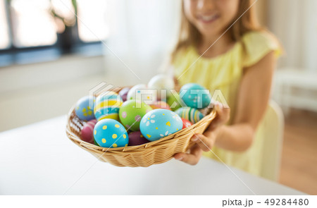 close up of girl with easter eggs in wicker basket 49284480