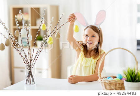 girl decorating willow by easter eggs at home girl decorating willow by easter eggs at home 49284483
