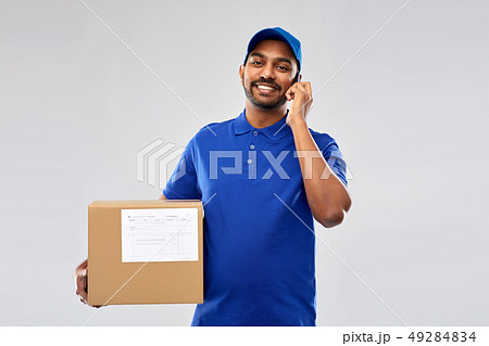 indian delivery man with smartphone and parcel box 49284834