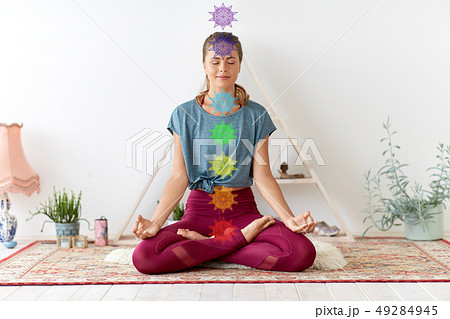 woman meditating in lotus pose at yoga studio woman meditating in lotus pose at yoga studio 49284945