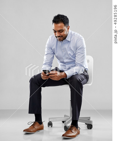 smiling indian businessman sitting on office chair 49285196