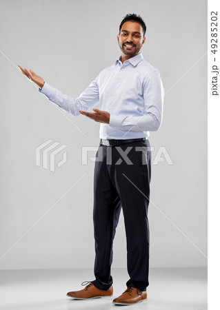 indian businessman holding something over grey indian businessman holding something over grey 49285202