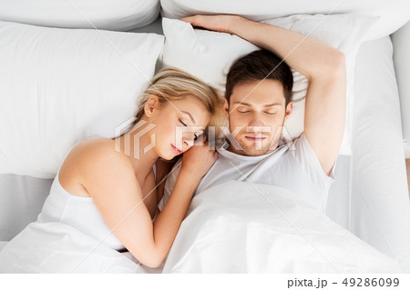 happy couple sleeping in bed at home happy couple sleeping in bed at home 49286099