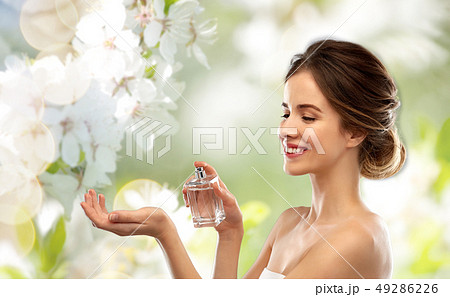 happy woman with perfume over cherry blossoms happy woman with perfume over cherry blossoms 49286226