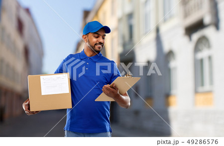 delivery man with parcel and clipboard in city 49286576