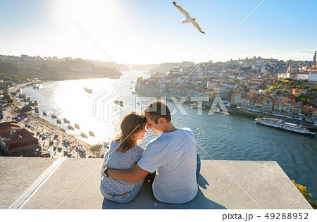 Couple relaxing on Porto in front of the skyline Couple relaxing on Porto in front of the skyline 49288952