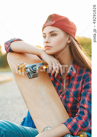 Pretty woman with skateboard in autumn day.  49291626