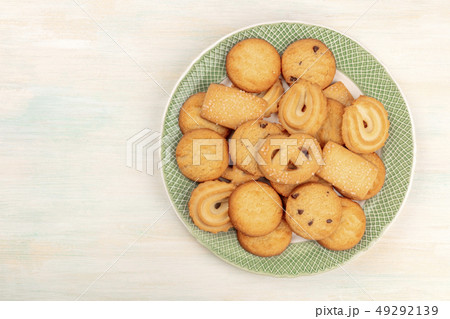 A photo of Danish butter cookies on a plate, shot from above on a white wooden background with a A photo of Danish butter cookies on a plate, shot from above on a white wooden background with a 49292139
