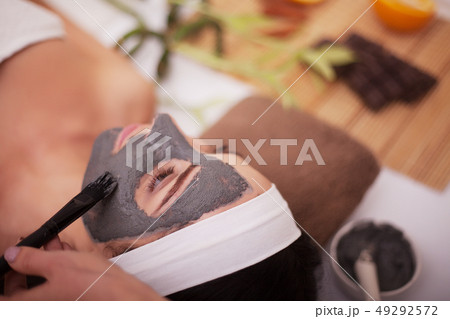 Applying facial mask at woman face at beauty salon 49292572