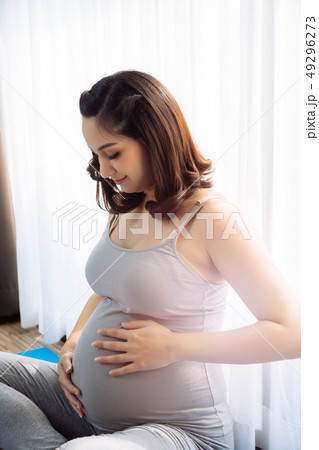 Young attractive pregnant woman touching her pregnant tummy Young attractive pregnant woman touching her pregnant tummy 49296273