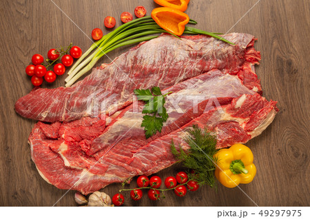 Raw beef on a wooden background with spices and Raw beef on a wooden background with spices and 49297975
