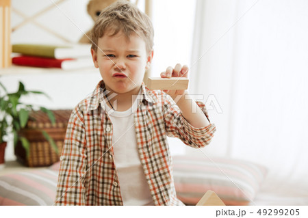 Little child sitting on the floor. Pretty boy palying with wooden cubes at home Little child sitting on the floor. Pretty boy palying with wooden cubes at home 49299205