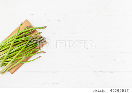 Fresh green asparagus on white wooden background Fresh green asparagus on white wooden background 49299617