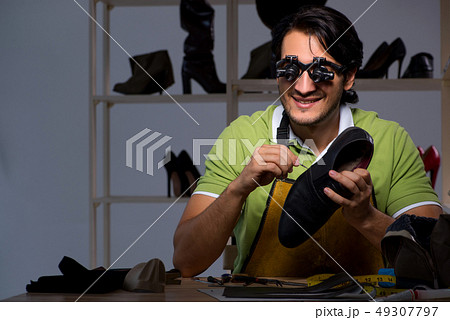 Young shoemaker in workshop at night  49307797