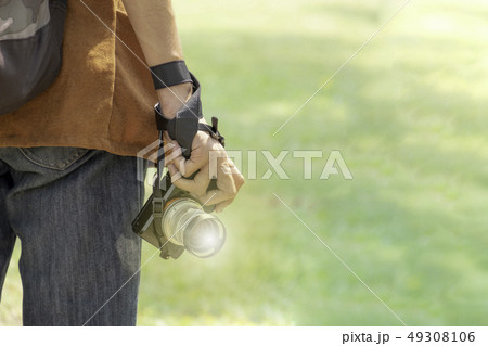 Young man with professional camera photographing Young man with professional camera photographing 49308106