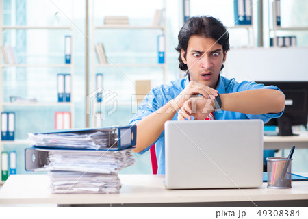 Handsome businessman unhappy with excessive work in the office Handsome businessman unhappy with excessive work in the office 49308384